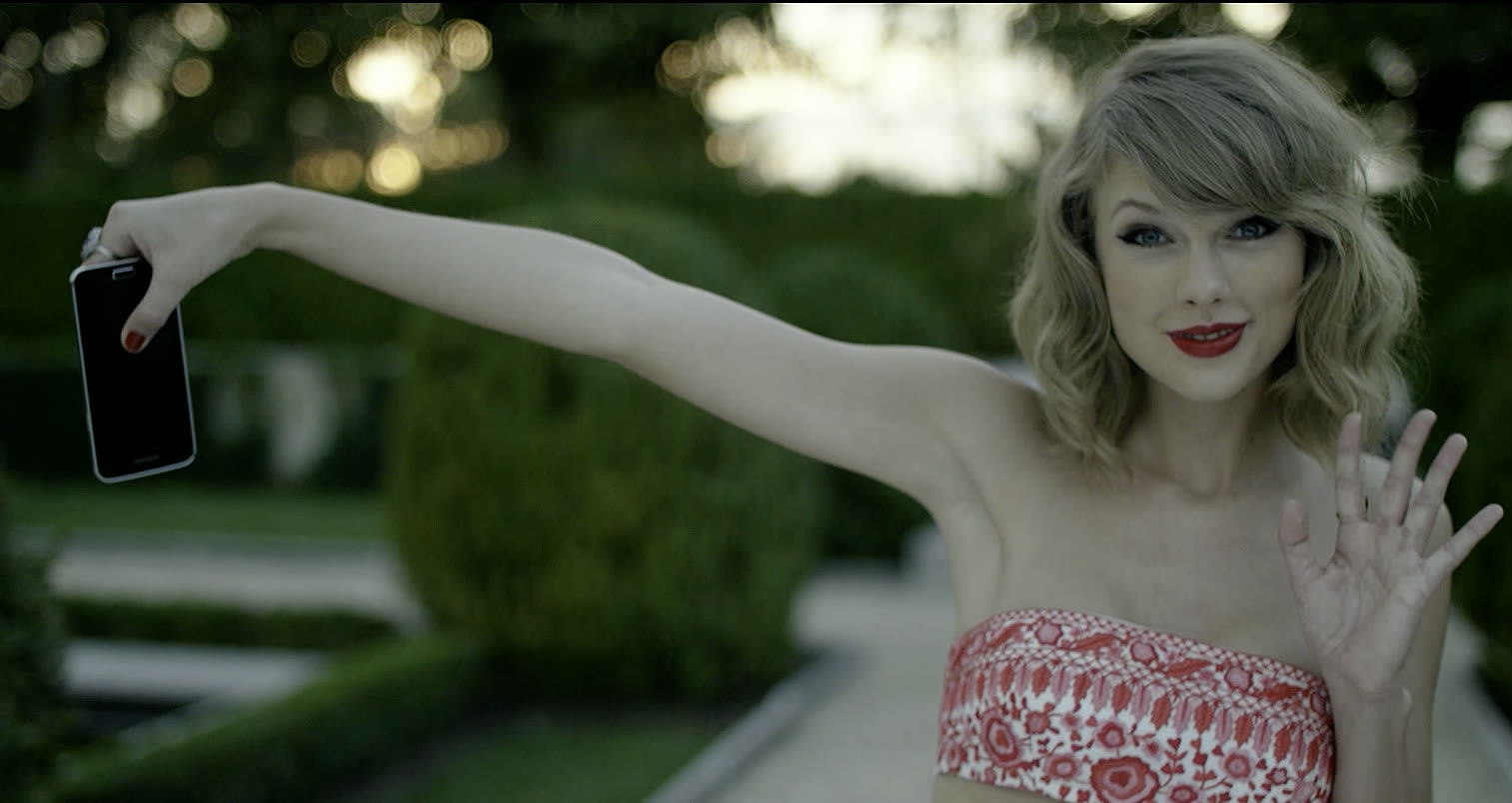 Taylor Swift holding out a phone in the Blank Space video — Justin Herrera&rsquo;s own phone, used as a prop on set