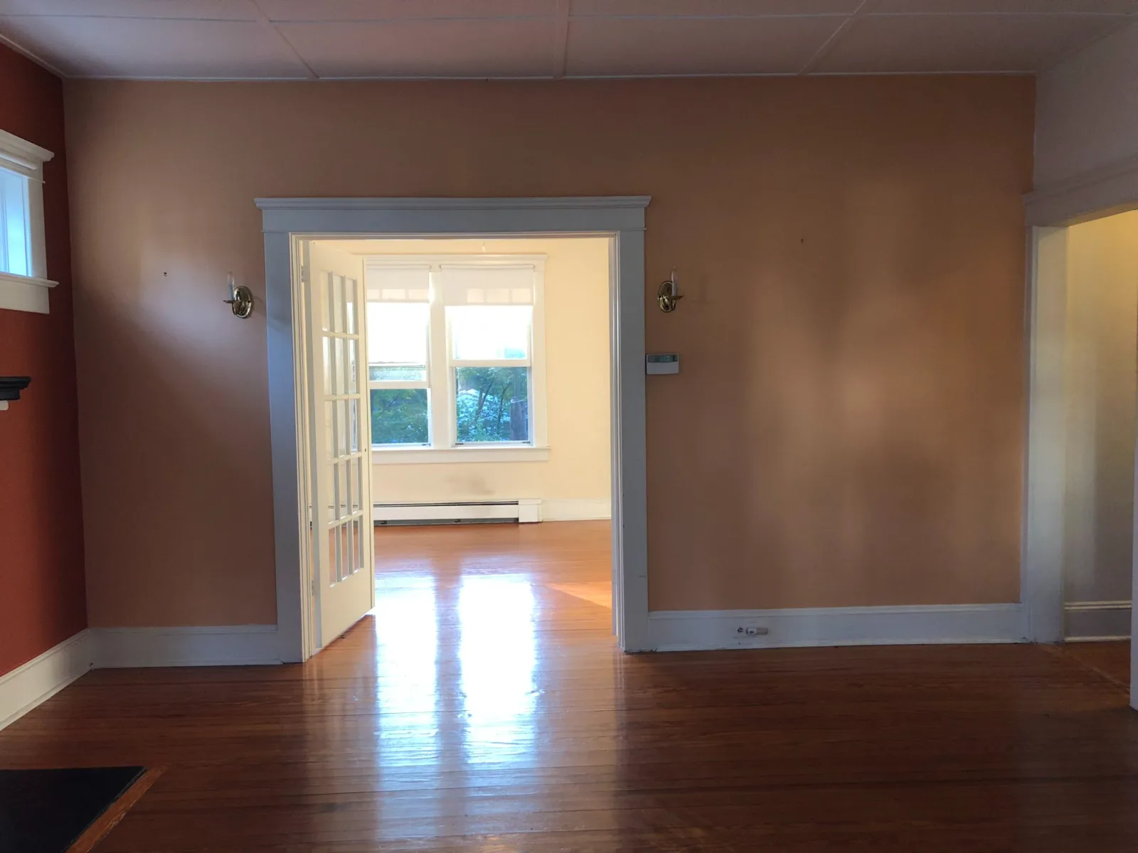 The same Western Ave rooms before renovation, with salmon walls and the original French doors.
