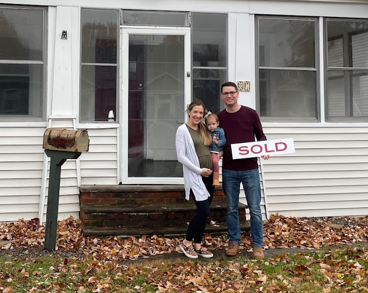 Justin and Steph holding a sold sign at 87 Fairchild