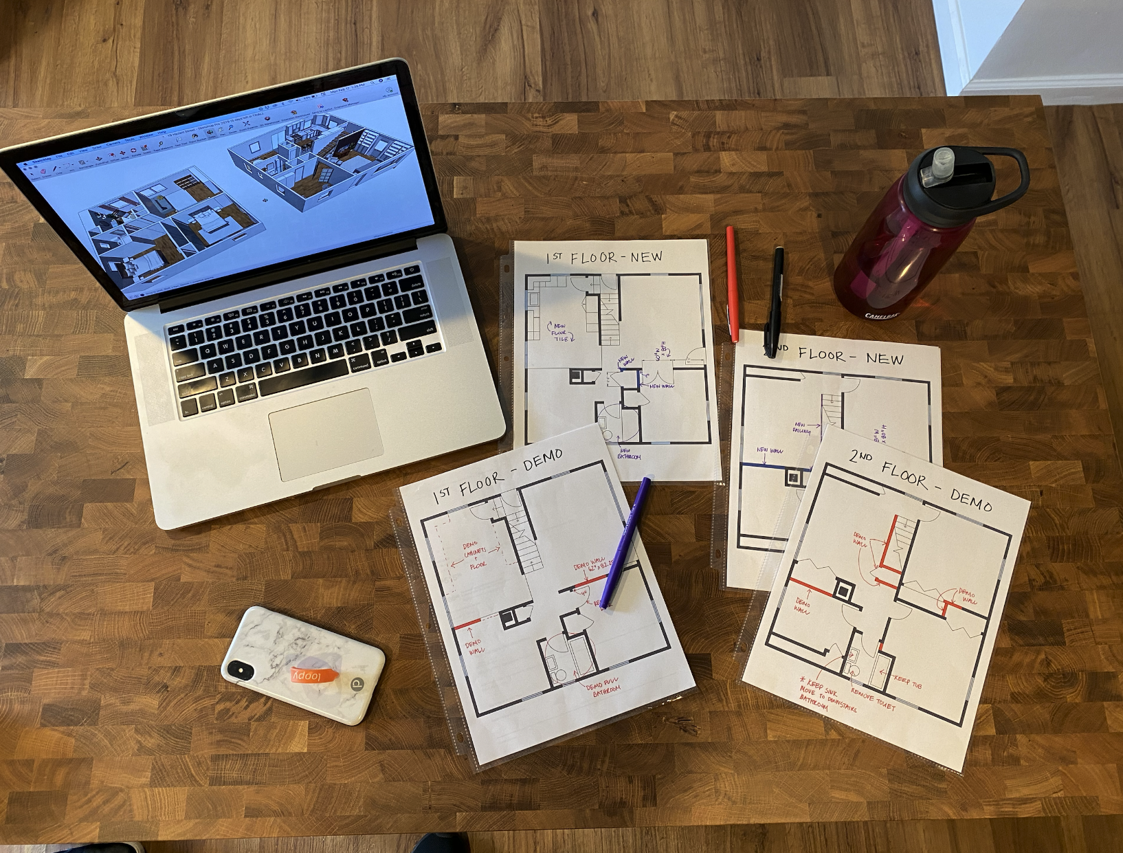 All four floorplans laid out on the table — demo, construction, kitchen, and finish